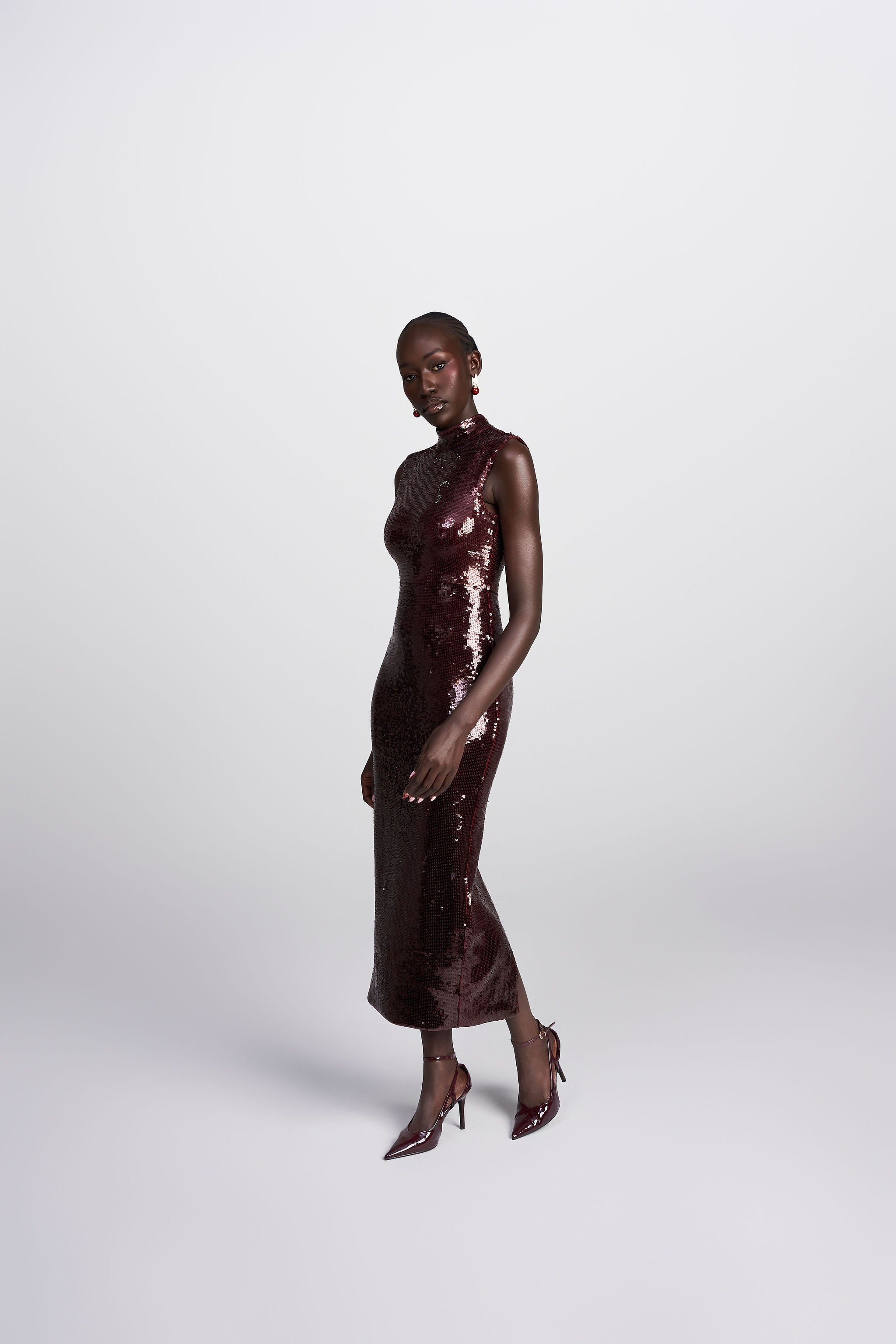 Dahlia wine sleeveless mock neck sequin midi dress front view
 back view showing back slit 
side profile walking 
 detail shot square cut sequin close up
lifestyle shot Australian luxury eveningwear